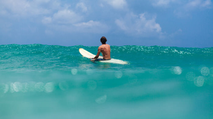 unidentified man surfing in the sea
